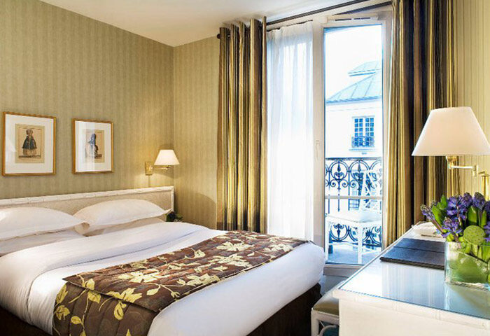 Hotel Turenne Le Marais room. Best opening gay hotel Paris city center. Balcony view, floral accents, and inviting bed.
