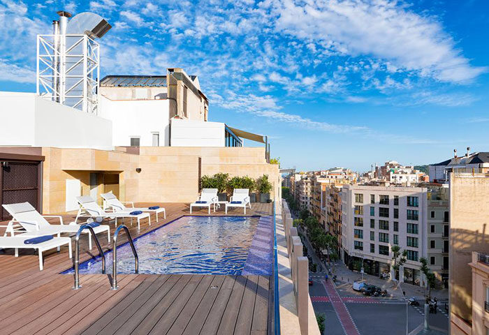 Rooftop pool at H10 Art Gallery Hotel, a gay hotel in Barcelona's Eixample district. Best rooftop view, sun loungers, and city skyline.