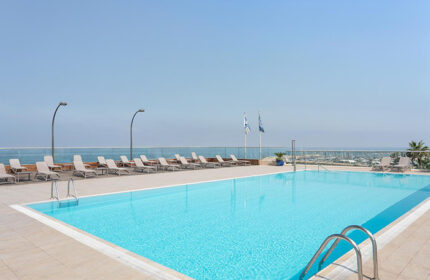 Sheraton Tel Aviv Hotel's rooftop pool. A luxury gay hotel with ocean views, lounge chairs, and clear blue water. Perfect for a gay travel getaway.