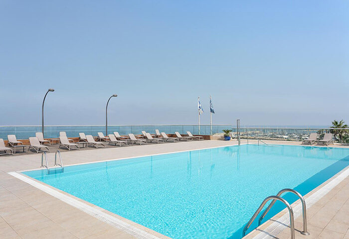 Sheraton Tel Aviv Hotel's rooftop pool. A luxury gay hotel with ocean views, lounge chairs, and clear blue water. Perfect for a gay travel getaway.