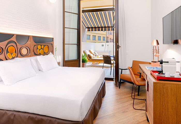 H10 Metropolitan Hotel Barcelona room. Upscale gay hotel with balcony, daybed, and modern decor. Best hotel for gay travel in Barcelona, Spain.