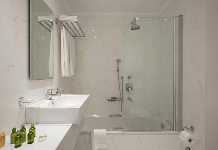 Despotiko Hotel bathroom. Modern, bright, and clean design. Bathtub with shower. Mykonos Town gay hotel, a cheap gay hotel in gayborhood.