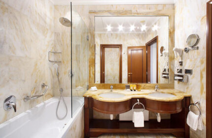 NH Collection Carlo IV, Prague Old Town: Bathroom with marble walls, double sink, large mirror, bathtub with shower. Gay-friendly hotel.