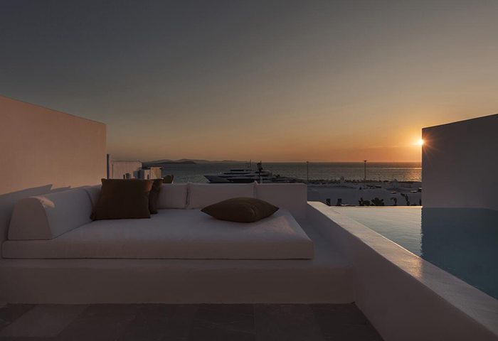 Porto Mykonos Hotel gay honeymoon idea. Sunset view from a suite with a daybed and private pool overlooking the Aegean Sea. Luxury travel.