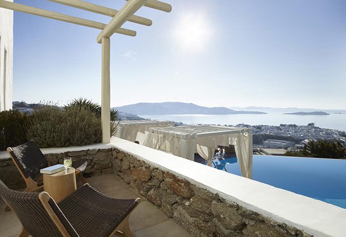 Mykonos Town's Vencia Boutique Hotel: Gay honeymoon destination with infinity pool view. Chairs, cabanas, Aegean Sea.