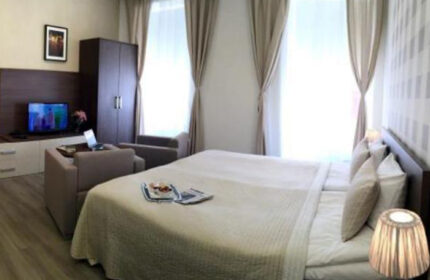 Hotel Residence Spalena room, Prague. Gay hotel in Vinohrady nightlife area. Modern room with double bed, TV, seating area, & natural light.