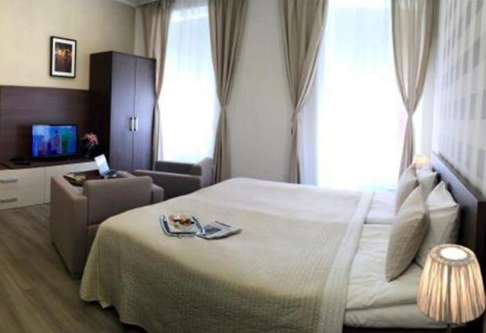 Hotel Residence Spalena room, Prague. Gay hotel in Vinohrady nightlife area. Modern room with double bed, TV, seating area, & natural light.