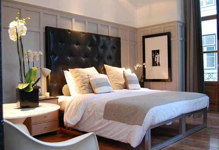 Browns Boutique Hotel Lisbon bedroom. This gay hotel in Lisbon city center features a large bed with a black headboard and neutral decor.
