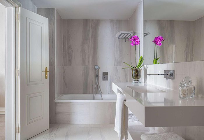 Tivoli Avenida Liberdade gay hotel bathroom in Lisbon. Luxurious marble, modern sink, bathtub, orchid. City Center hotel for gay men.