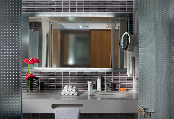 Dan Tel Aviv Hotel bathroom detail. Luxury beachfront gay hotel in Hilton Beach, Tel Aviv. Stylish sink, mirror, and amenities.