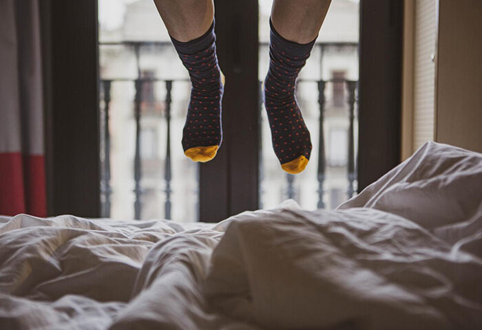 Feet in socks dangle above a bed in TOC Hostel Barcelona. Enjoy gay nightlife in this city center hostel.