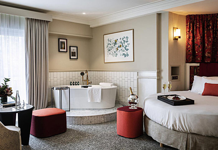 Sofitel Le Scribe Paris Opéra gay hotel suite. Round bed, champagne, and bathtub. Luxury gay travel in Paris' gayborhood.