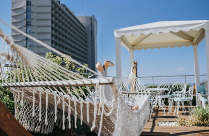 Gay honeymoon at Shalom Hotel Relax, Tel Aviv. Person relaxing in a hammock on a rooftop terrace near Hilton Beach. Boutique hotel.