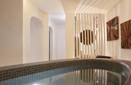 Jacuzzi at Absolute Mykonos Suites, a popular gay honeymoon hotel in Mykonos Town's gayborhood. Modern design with wooden accents.