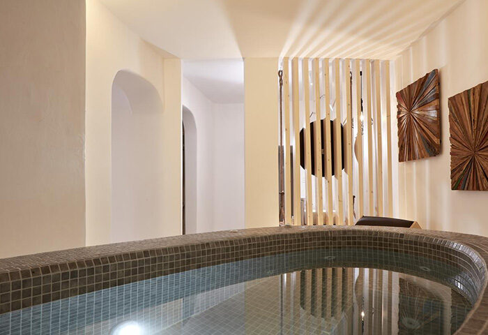 Jacuzzi at Absolute Mykonos Suites, a popular gay honeymoon hotel in Mykonos Town's gayborhood. Modern design with wooden accents.
