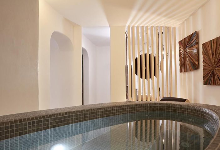 Jacuzzi at Absolute Mykonos Suites, a popular gay honeymoon hotel in Mykonos Town's gayborhood. Modern design with wooden accents.