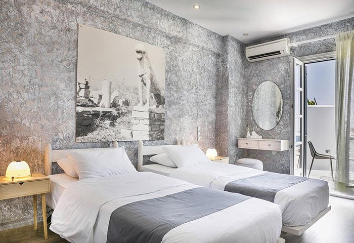 Ilio Maris, Mykonos Town gay honeymoon hotel room. Two beds, gray walls, balcony. Popular gay travel destination. This Year Update.