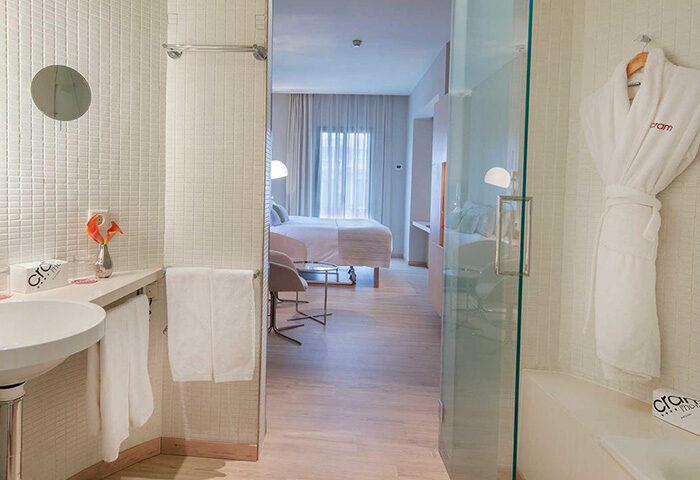 Cram Hotel Barcelona room. Gay-friendly hotel with city center location and gay nightlife access. Modern bathroom with robe and bedroom view.