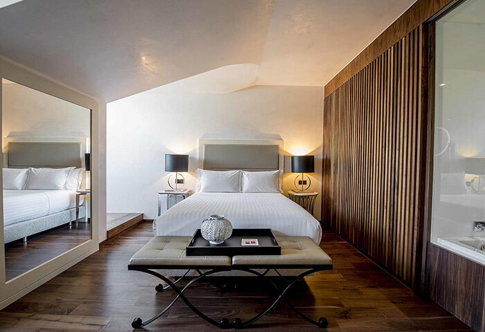 BessaHotel Liberdade honeymoon suite in Lisbon city center. Popular gayborhood hotel room with bed, lamps, and modern design.