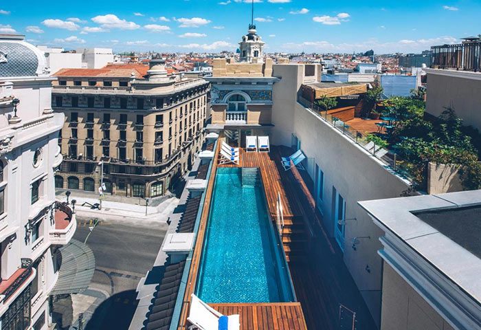 Iberostar Las Letras Gran Vía rooftop pool in Madrid. A top gay hotel with stunning city views, perfect for a gay travel getaway.