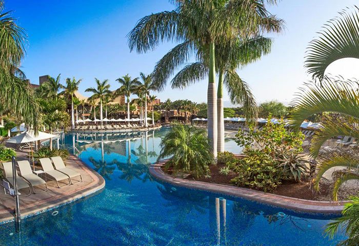 Lopesan Baobab Resort, Gran Canaria. Luxury gay hotel pool view with palm trees, sunbeds, and clear blue water. Meloneras Beach vacation.