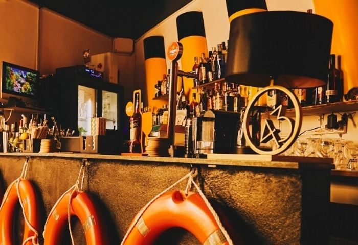 Titanic Bar, a gay bar in Barcelona. Interior shot of the bar with life preservers, bottles, and nautical themed decor.