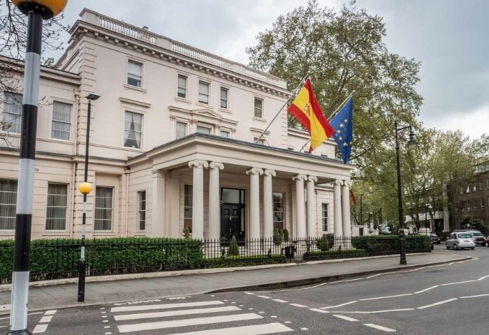Spanish Embassy building in London. Flags of Spain and the European Union are displayed. Gay travel advice for LGBTQ+ tourists.