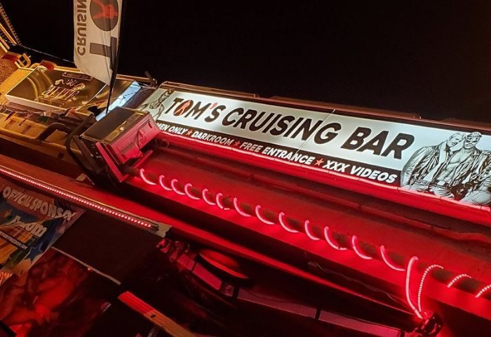 Tom's Cruising Bar, a gay club in Gran Canaria. Neon sign with men only and darkroom. Gay travel destination for men.