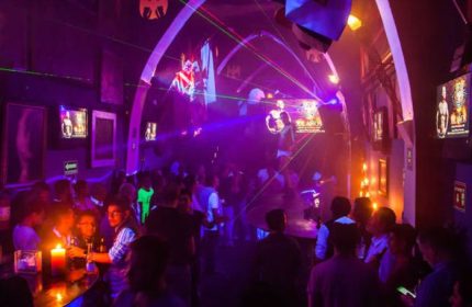 Tom's Leather Bar: Gay party in Mexico with drinks, purple lights, and people dancing. Gay travel advice in Puerto Vallarta.