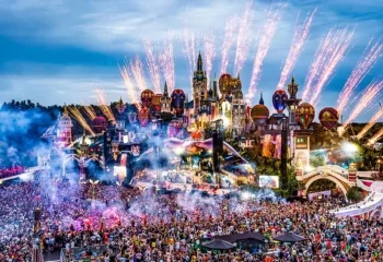 Drone shot of tomorrow land past event. Huge crowd, fireworks festival backdrop.