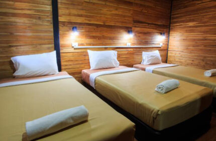 Ton Sai Beachfront Gay Hotel, Phi Phi Island: Three beds in a room with wooden walls, pillows, and rolled towels, perfect for gay travel.
