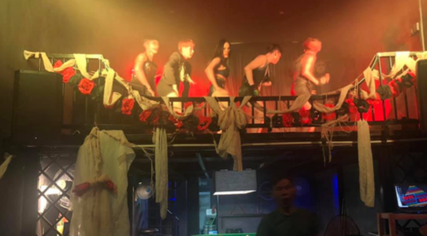 ToolBox Bar Phnom Penh: Performers on a decorated stage. Gay travel advice, nightlife scene. Red roses, fabric, and moody lighting. Cambodia.