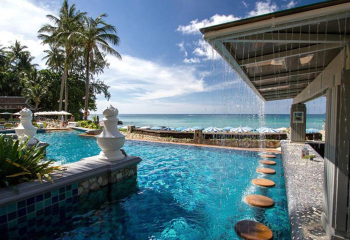 Beyond Resort Karon, Phuket adults-only beachfront hotel pool. Gay travel: luxury swimming pool, ocean view, palm trees, and bar.