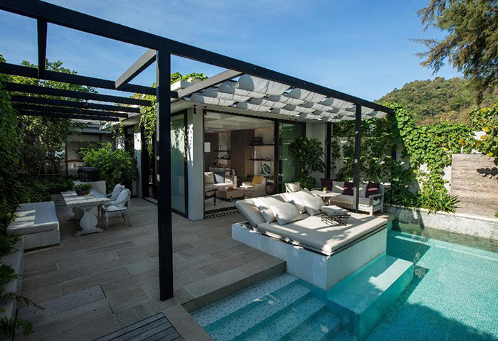Rosewood Phuket gay hotel pool villa. Luxury Mr and Mr travel. Outdoor living space with daybed, dining area, and private pool. Tropical getaway.