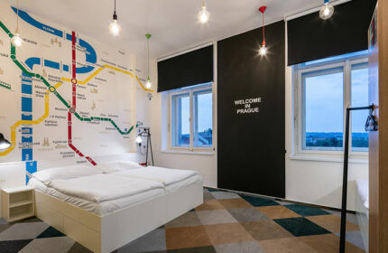 meetme23 party hostel room in Prague's gayborhood. Metro map mural, double bed, Welcome in Prague text. Top choice for gay travelers in Vinohrady.