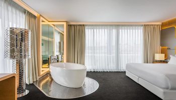 Room Mate Oscar, gay hotel Madrid. Modern room with bathtub, bed, and large windows. Top gay-friendly hotel with rooftop pool.