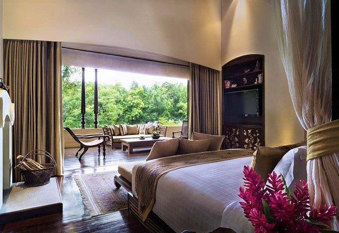Four Seasons Resort Chiang Mai suite. Luxury gay-friendly hotel with balcony, outdoor seating, and lush green views. Perfect for gay travel.