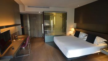 Hotel Soho, Barcelona. Modern room interior, part of top budget gay hotel. Comfy bed, desk, and glass-enclosed shower.