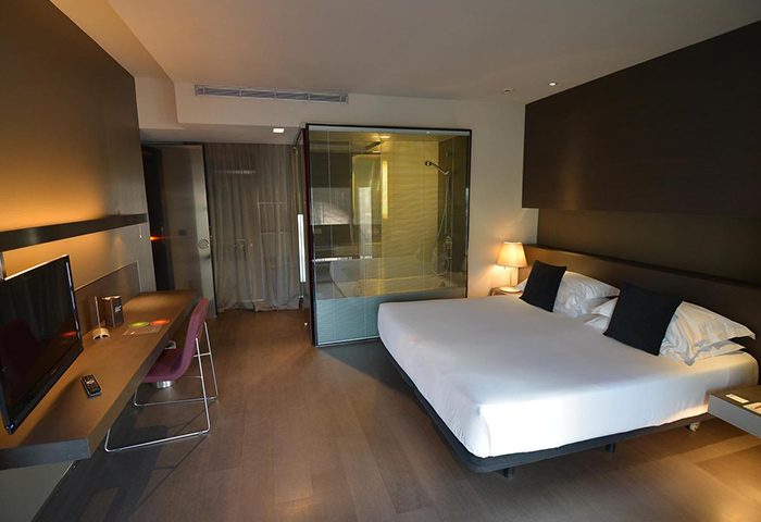Hotel Soho, Barcelona. Modern room interior, part of top budget gay hotel. Comfy bed, desk, and glass-enclosed shower.