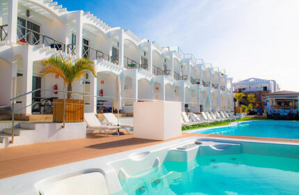 Vista Bonita Gay Only Resort pool view. Top choice gay hotel near gay nightlife with pool and jacuzzi. White architecture, sunny day.