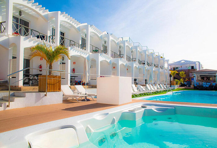 Vista Bonita Gay Only Resort pool view. Top choice gay hotel near gay nightlife with pool and jacuzzi. White architecture, sunny day.