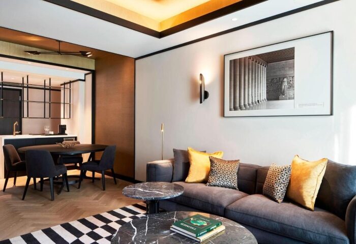 Academias Hotel, Autograph Collection: Athens hotel room with modern design, gray sofa, marble tables, & black & white rug. Gay couples' choice.