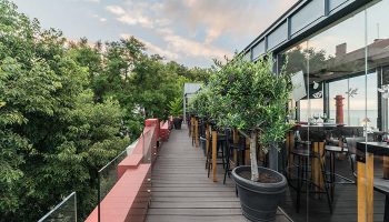 Monte Belvedere Hotel by Shiadu rooftop bar in Lisbon. Top city-center gay hotel with outdoor seating, trees, and modern design.
