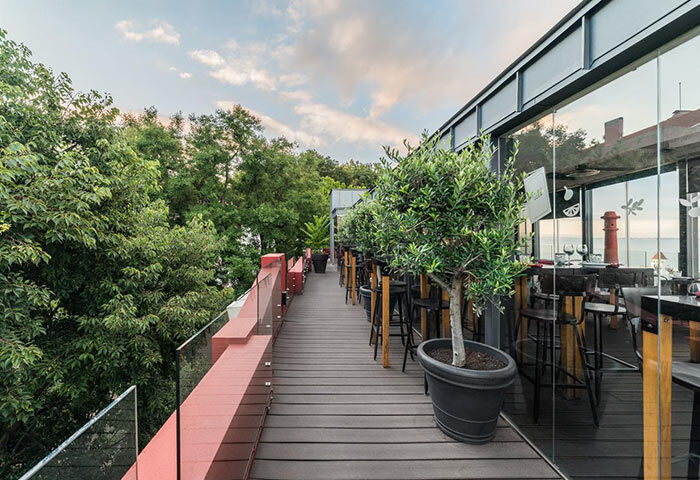 Monte Belvedere Hotel by Shiadu rooftop bar in Lisbon. Top city-center gay hotel with outdoor seating, trees, and modern design.