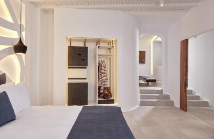 Stylish decor at Absolute Mykonos Suites & More, a gay hotel near Mykonos City Center. Cool room interior with bed, closet, and stairs.