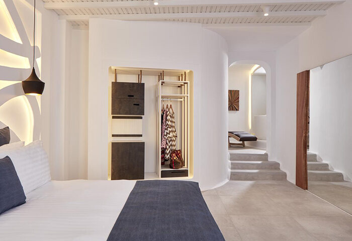 Stylish decor at Absolute Mykonos Suites & More, a gay hotel near Mykonos City Center. Cool room interior with bed, closet, and stairs.