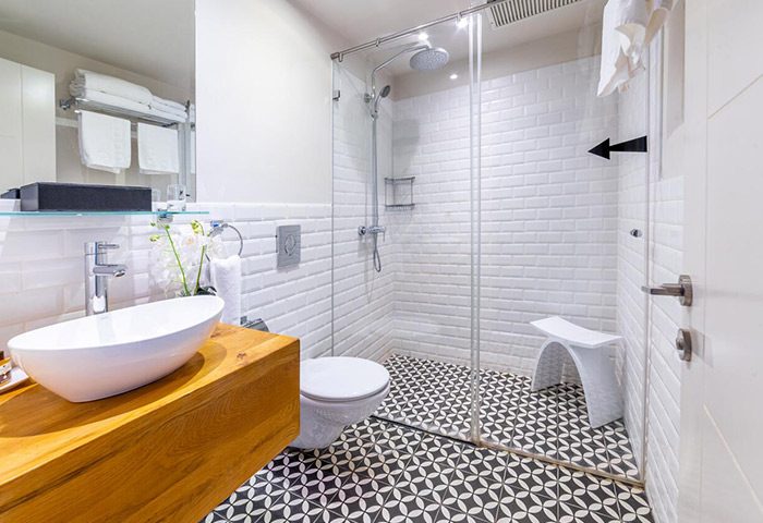 Shenkin Hotel's stylish bathroom in Tel Aviv city center. Cool design with modern sink, shower, and black & white patterned floor. Gay hotel.