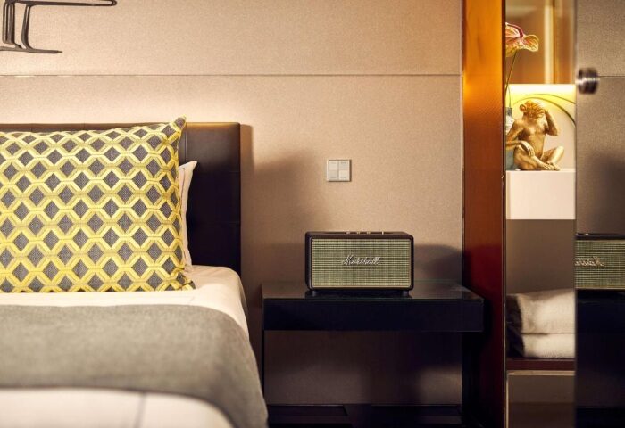art'otel Amsterdam room detail. Bedside table with Marshall speaker, decorative pillow, and art piece. Top crazy art design at gay hotel.