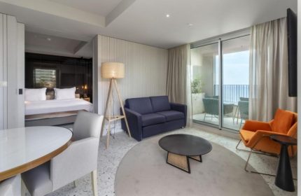 NEXT Hotel Madeira room interior. Gay honeymoon hotel in Portugal with balcony, sofa, and bed. Top gay beach destination.