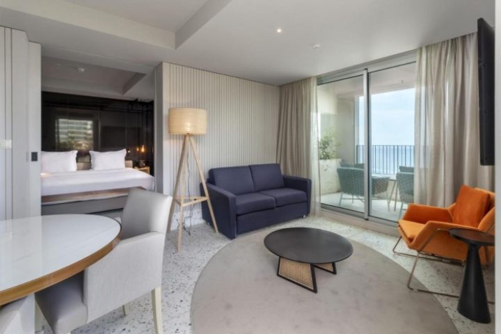 NEXT Hotel Madeira room interior. Gay honeymoon hotel in Portugal with balcony, sofa, and bed. Top gay beach destination.
